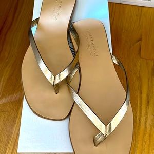 NWT gold leather flip flops, size 7. Saks brand.